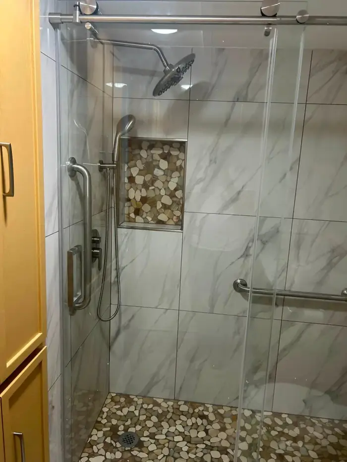 Marble-look walk-in shower with glass door from a bathroom remodel by RGS General Contracting