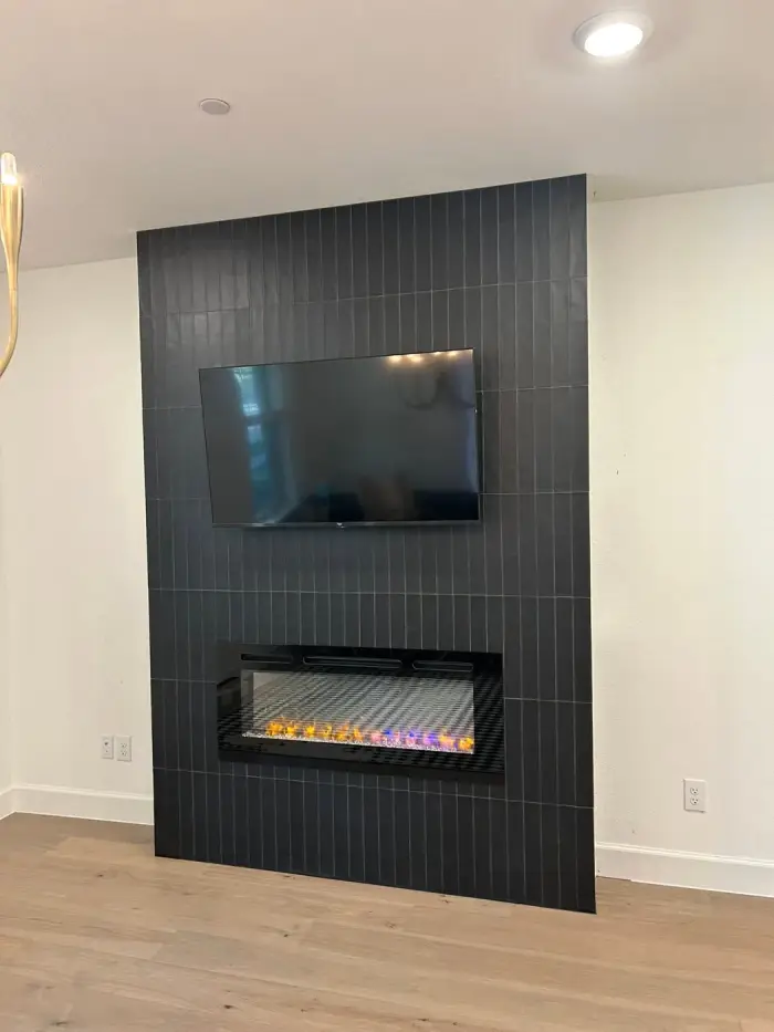 Custom tiled fireplace feature wall with mounted TV by RGS General Contracting